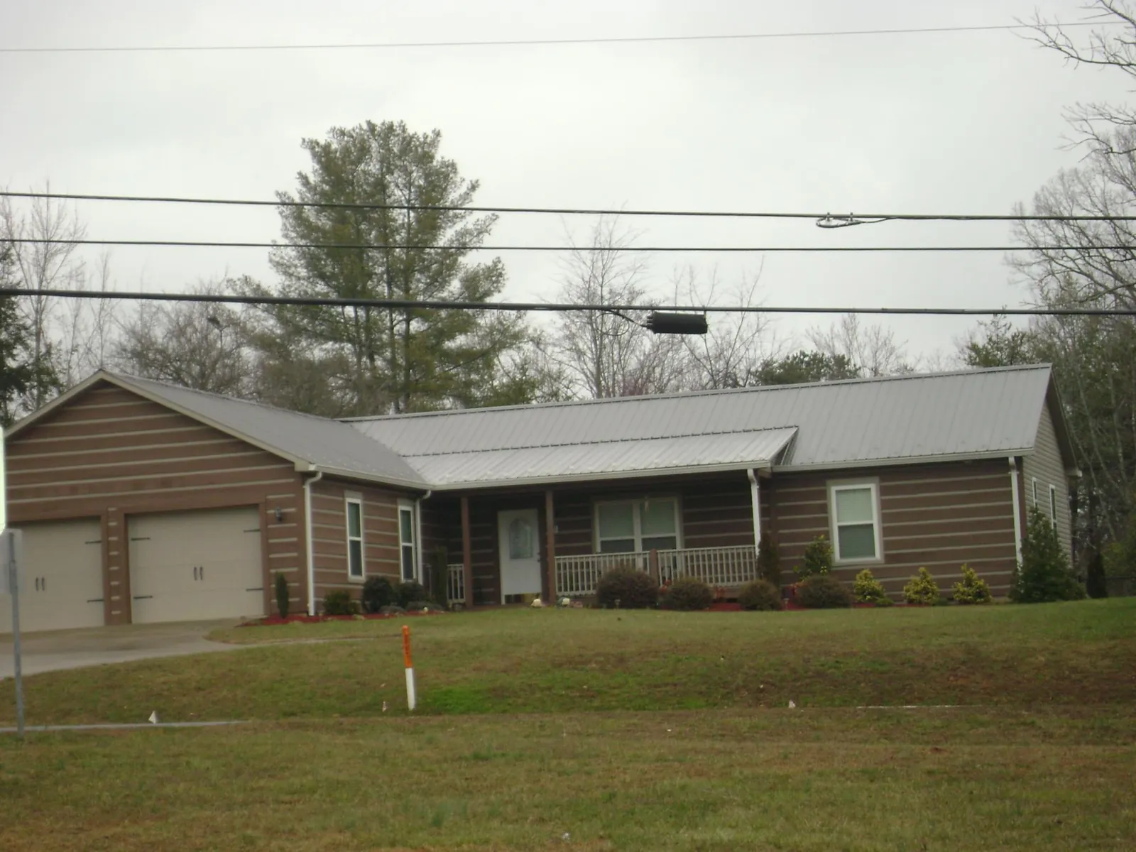 Gray metal roof on a log sided ranch home with a front porch in Carbondale